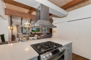 A modern kitchen with a central island, stainless steel appliances, and a built-in oven.