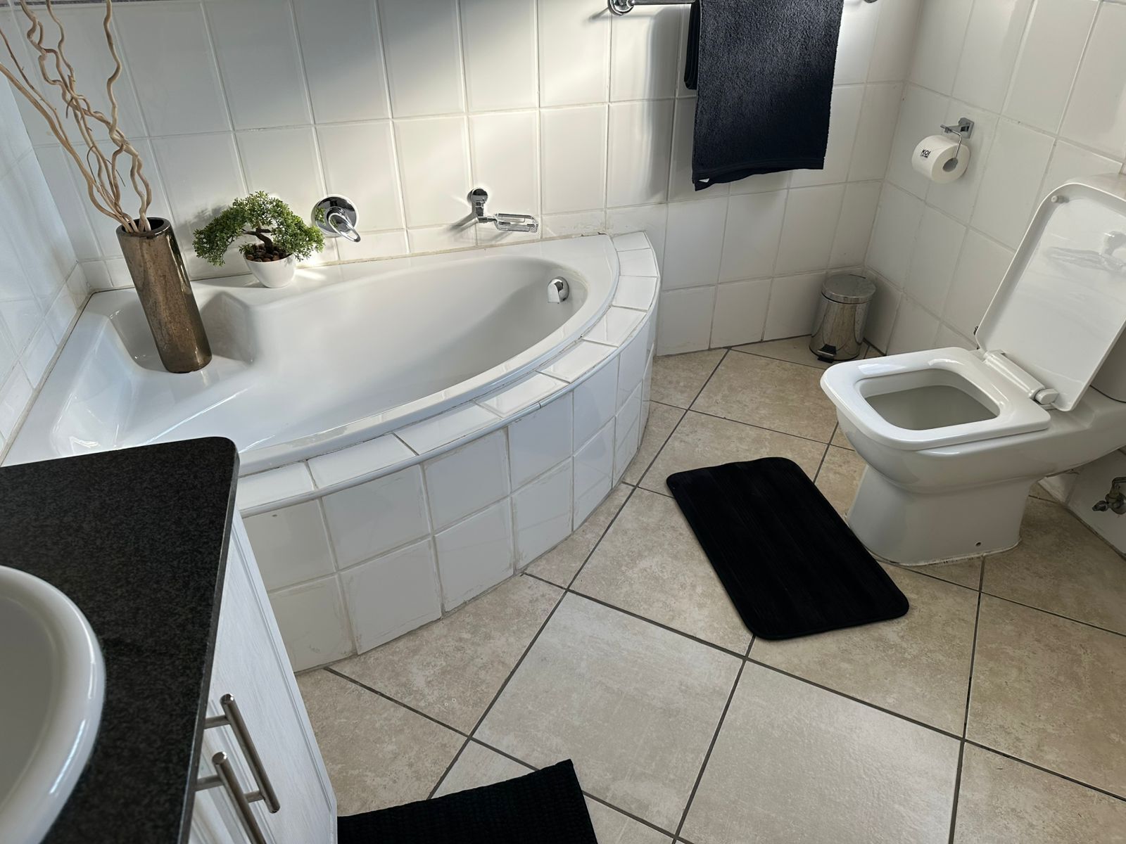 A modern bathroom with a bathtub, toilet, and sink.