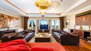 A spacious living room with leather sofas, a large flat-screen TV, and a chandelier. - Relax like a Renaissance nobleman in the six rooms of Villa Trsteno  (Trsteno)