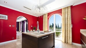 A modern kitchen with a central island, a large window with curtains, and a view of the outdoors. - Relax like a Renaissance nobleman in the six rooms of Villa Trsteno  (Trsteno)