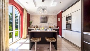 A modern kitchen with a central island, stainless steel appliances, and a large window with curtains. - Relax like a Renaissance nobleman in the six rooms of Villa Trsteno  (Trsteno)
