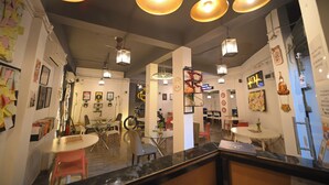 A modern interior with round tables, chairs, and hanging pendant lights.