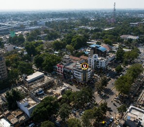 An urban area with a mix of commercial and residential buildings, a prominent U-shaped structure, and a dense network of roads. - HOTEL UR ( Nearby Prayagraj Junction & High Court) (Prayagraj)