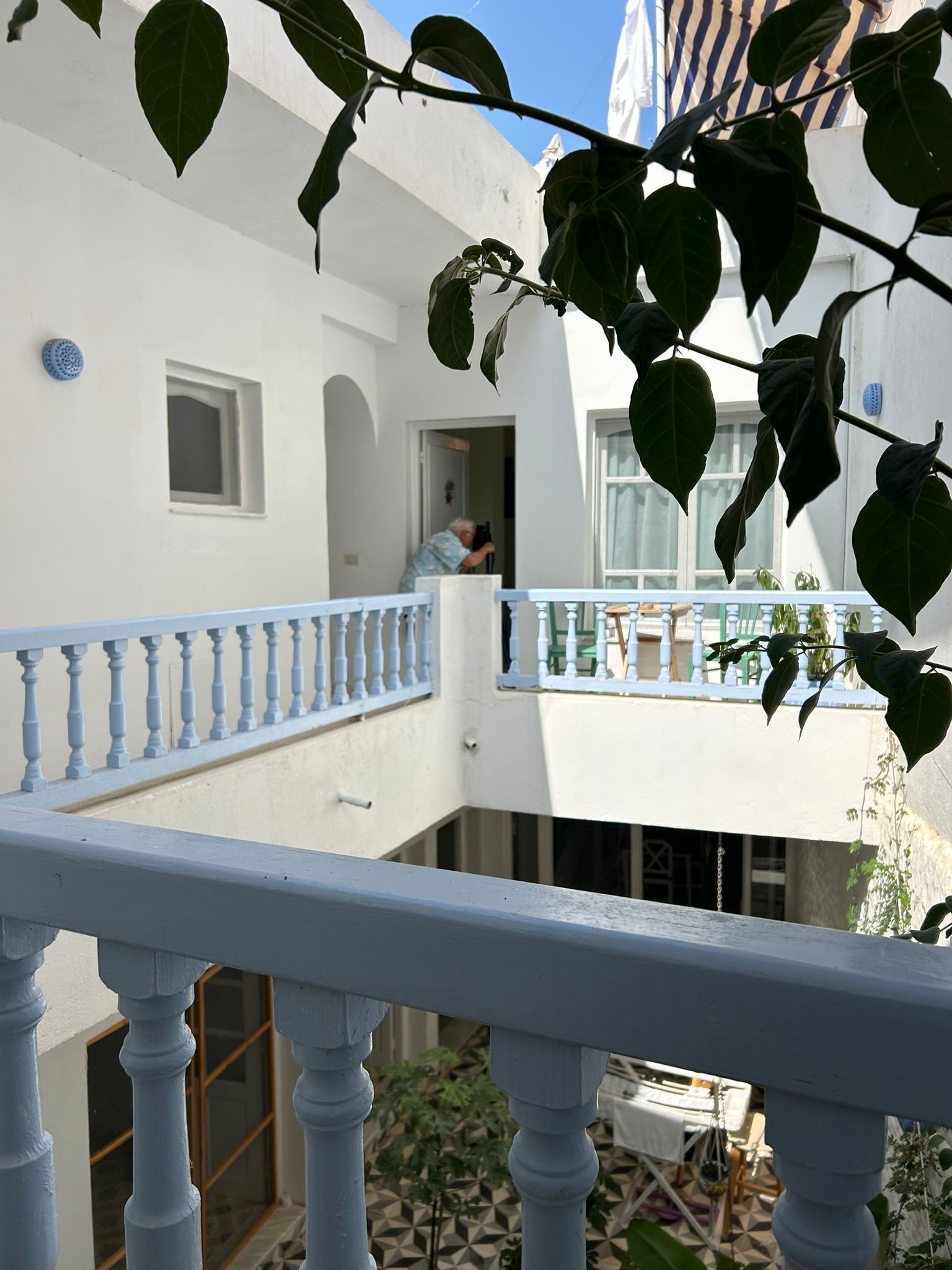 Ein weißes Gebäude mit Balkon, kleinem Fenster und Tür.