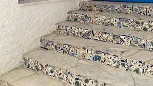 A staircase with mosaic tiles leading to a blue door. - dar Yessine (Hergla)