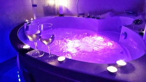 A hot tub with two glasses of champagne, surrounded by candles. - Doug's Mountain Getaway (Fulpmes)