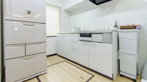 Una cocina moderna con electrodomésticos blancos, un microondas y un lavamanos pequeño.