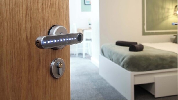 A modern room with a wooden door, a bed with a green bedspread, and a desk with a chair. - £ - City Centre - Duke Street Studio ~ 5* Location (Liverpool)