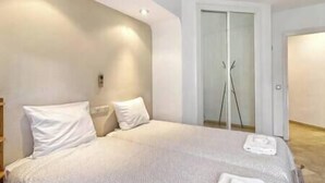 Ein Schlafzimmer mit Bett, Kleiderschrank und Duschbereich.