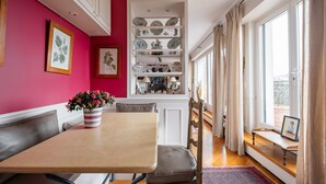 A dining area with a table, chairs, and a vase of flowers.