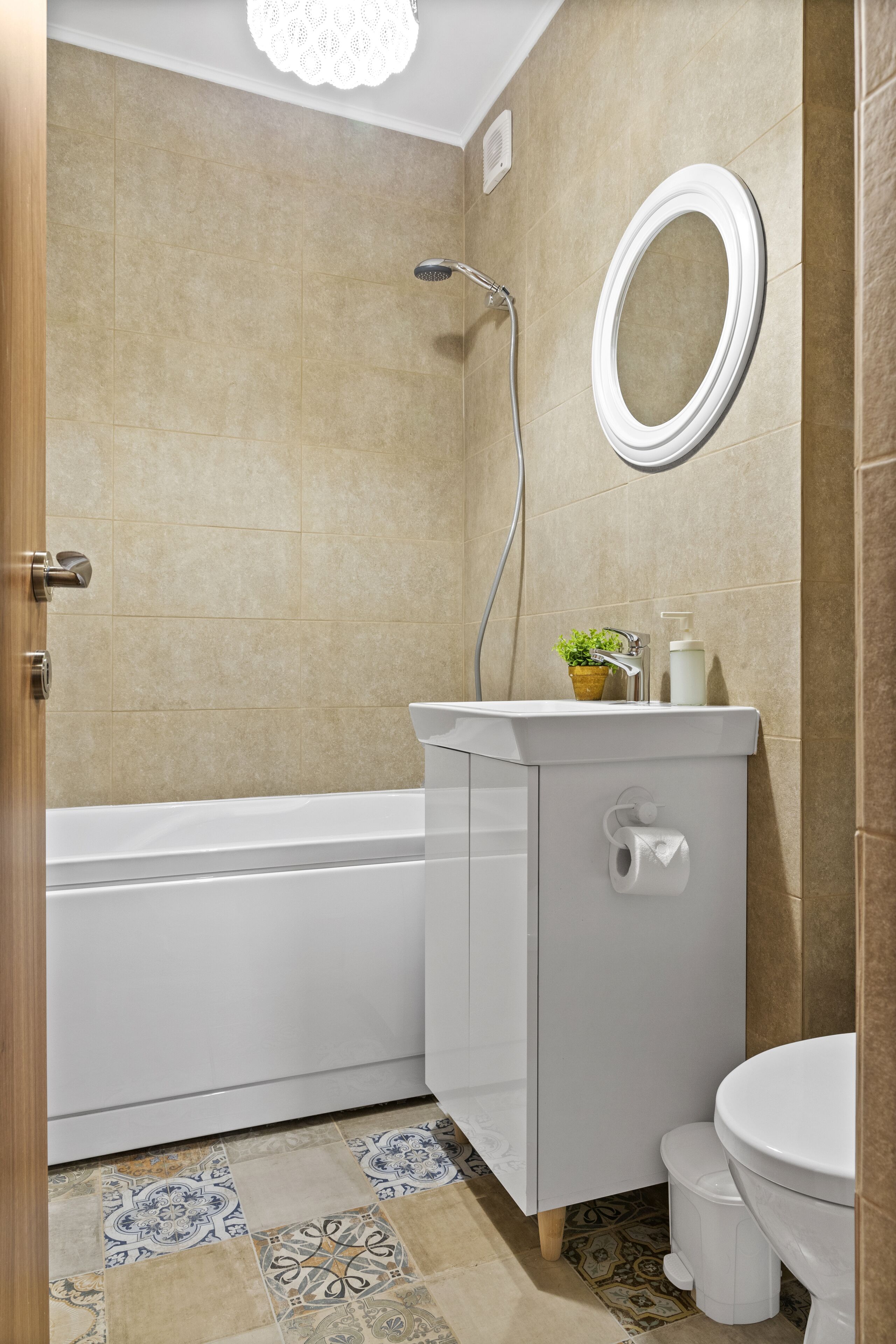 Un baño con bañera, inodoro, lavamanos y espejo.