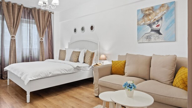 Una camera da letto con un letto, un divano, un tavolino e un quadro appeso al muro.