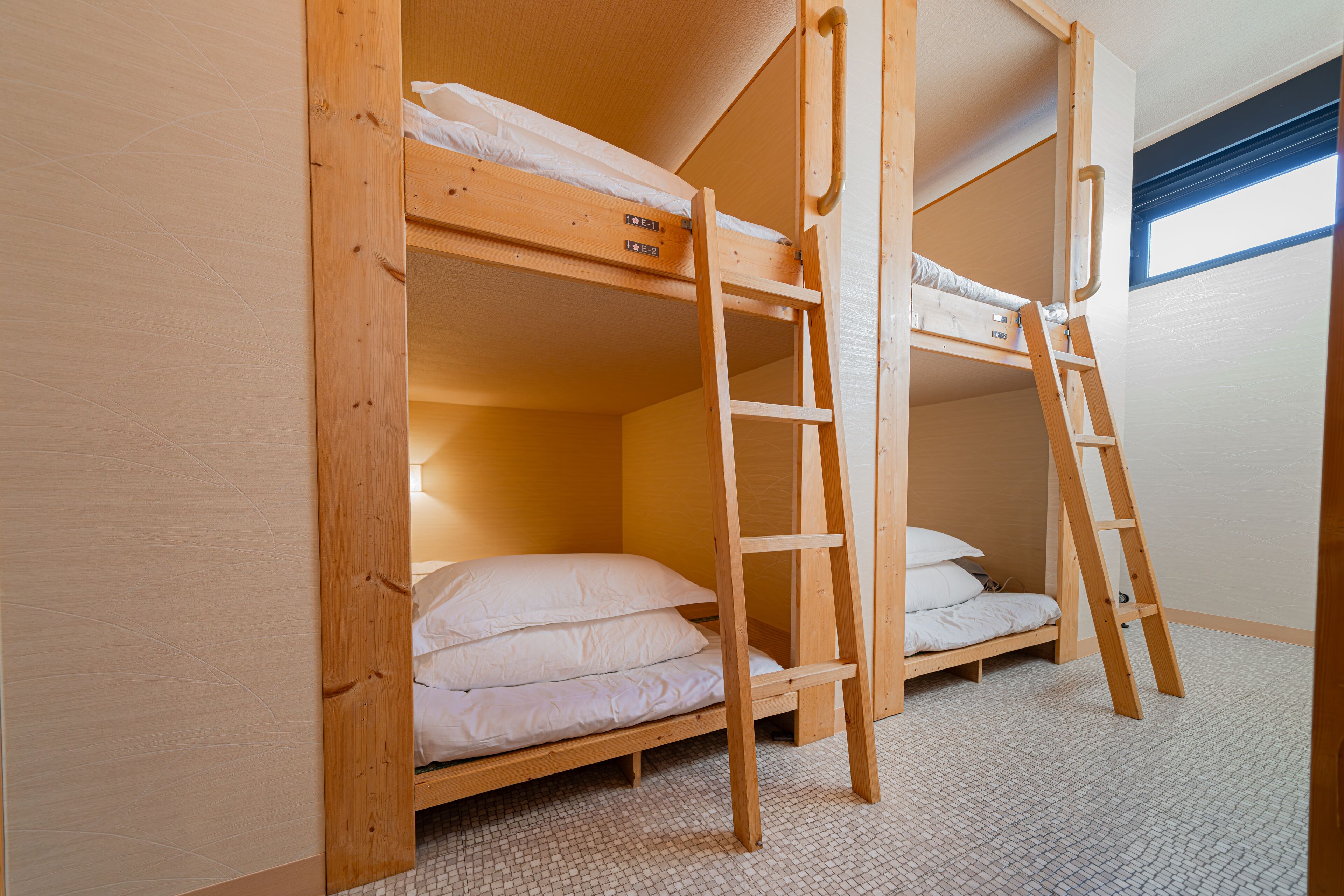 A bunk bed room with a ladder and a window.