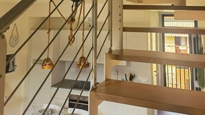 A staircase with metal railings and a wooden finish, leading to a dining area with a table set for a meal.