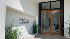 Une entrée moderne avec une enseigne indiquant « RÉSIDENCE HAKKA ».