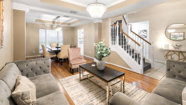 A spacious living room with a chandelier, a staircase, and a dining area with chairs and a table. - 4BDR+PrivatePool+Game Room+BBQ+FirePit+Fits12 (Corpus Christi)