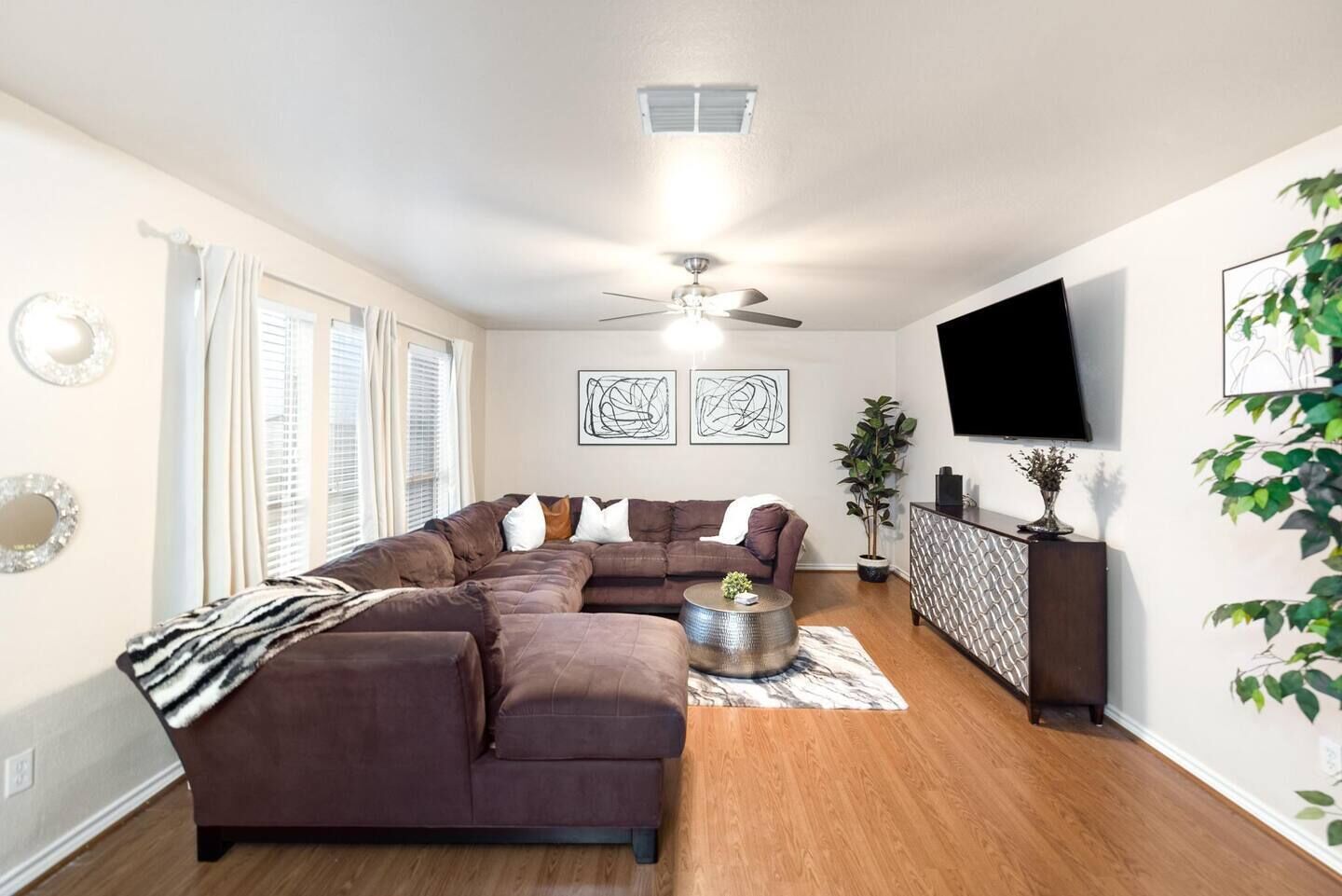 Una sala de estar moderna con un sofá modular, una mesa de centro y un televisor de pantalla plana montado en la pared.