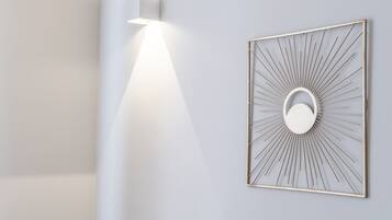 Una lámpara de pared con forma de sol naciente, con un elemento circular central y un marco geométrico.