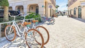 Eine gepflasterte Straße mit abgestellten Fahrrädern entlang des Bürgersteigs, ein Gebäude mit der Beschilderung 'Paradise Found' und einem klaren Himmel.