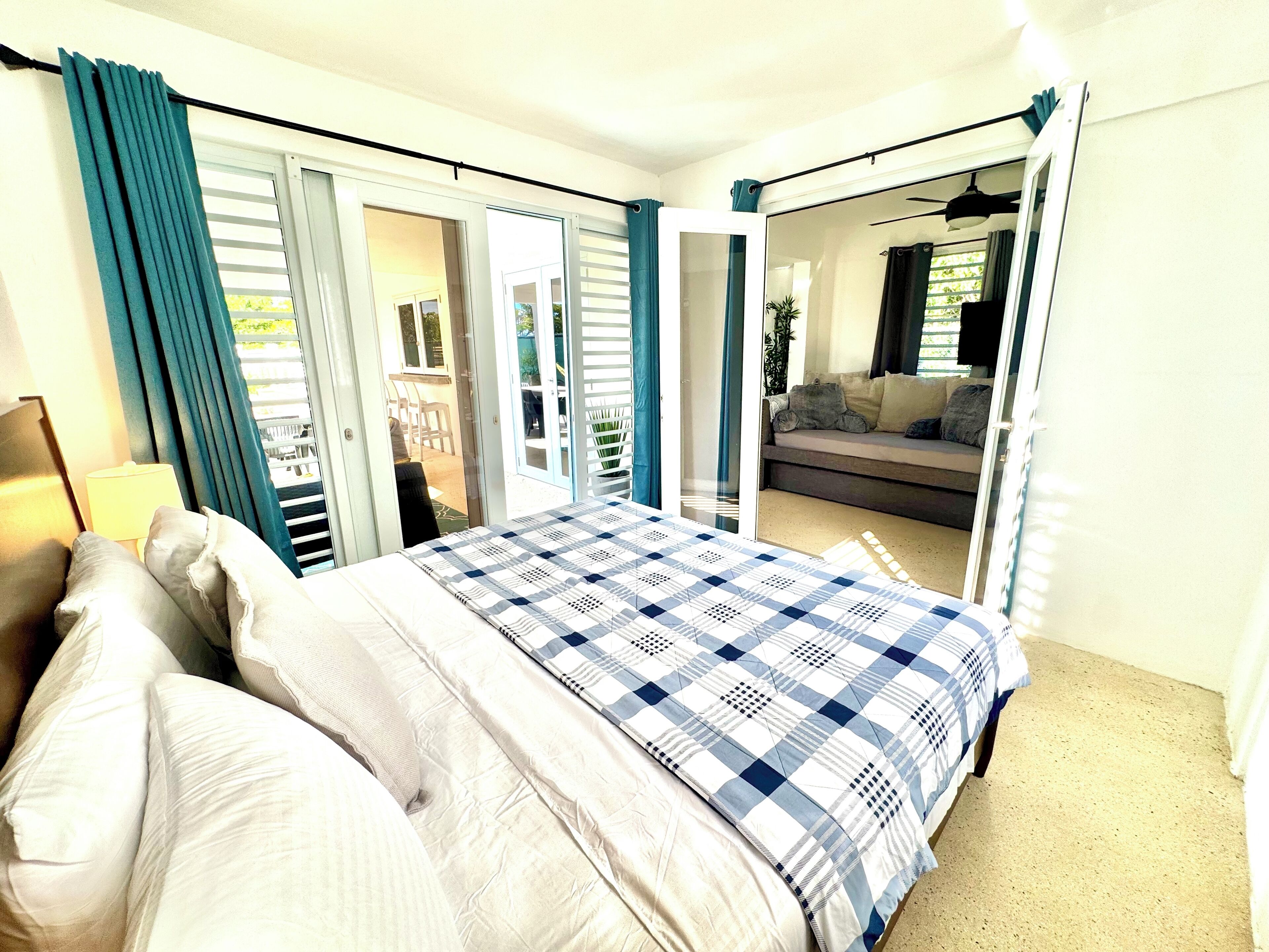 A bedroom with a bed, a nightstand, and a window with curtains.