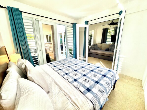 A bedroom with a bed, a nightstand, and a window with curtains.