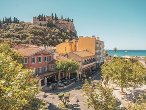 A hotel with a terrace, a view of the sea, and a historic building in the background. - Hôtel Liautaud Cassis by Germain Collection (Cassis)