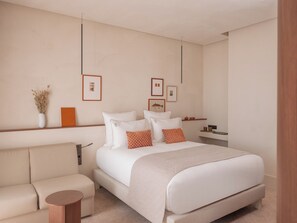 A modern bedroom with a large bed, a sofa, a side table, and framed pictures on the wall. - Hôtel Liautaud Cassis by Germain Collection (Cassis)