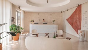 A modern hotel lobby with a reception desk, seating area, and a large wall map. - Hôtel Liautaud Cassis by Germain Collection (Cassis)