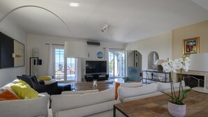 Una sala de estar moderna con un conjunto de sofá, un televisor de pantalla plana y una mesa de centro.