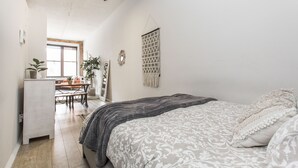 Ein Schlafzimmer mit Bett, Deckenventilator, Schreibtisch und Fenster.