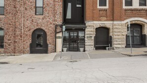 A building with a stone facade, a black entrance, and a brick section with windows. - Loft in the Rivermarket District! Rooftop access and DT KC views. Walk to City Market, local coffee shops, restaurants, shops or hop on the free streetcar just steps away. Minutes from  P&L, T-Mobile, Crossroads, Plaza. 10 min drive to stadiums. (Kansas City)