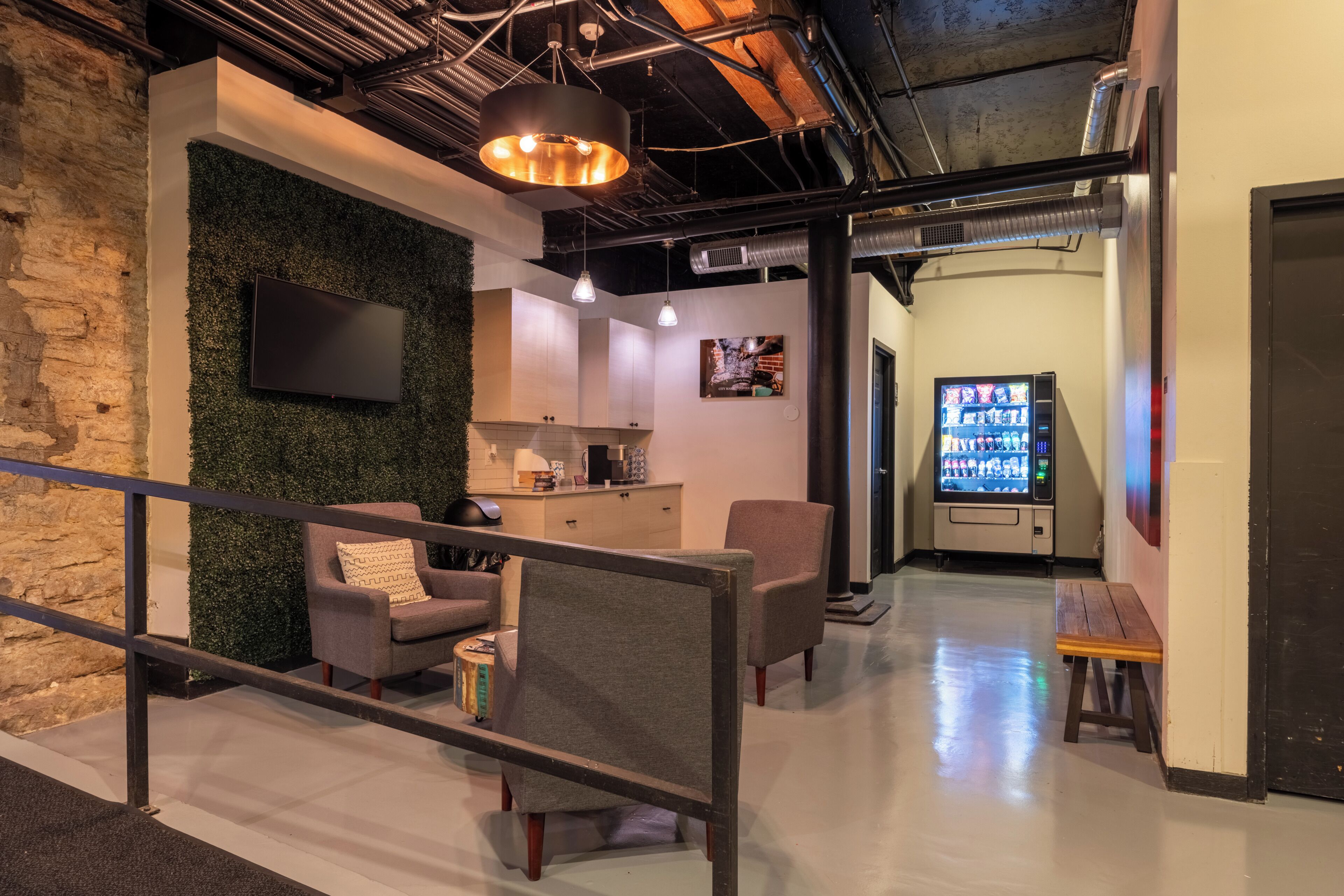 Een modern interieur met zitplaatsen, een flatscreen televisie en een automaat.
