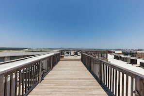 Eine Holzterrasse mit Geländer, die zu einem Blick auf eine Stadtlandschaft führt.