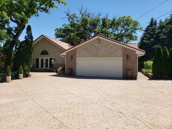 A two-story house with a brick facade, a large garage, and a paved driveway. - Ultimate Family Vacation Villa With Amazing Views - 3891 (Ottawa)
