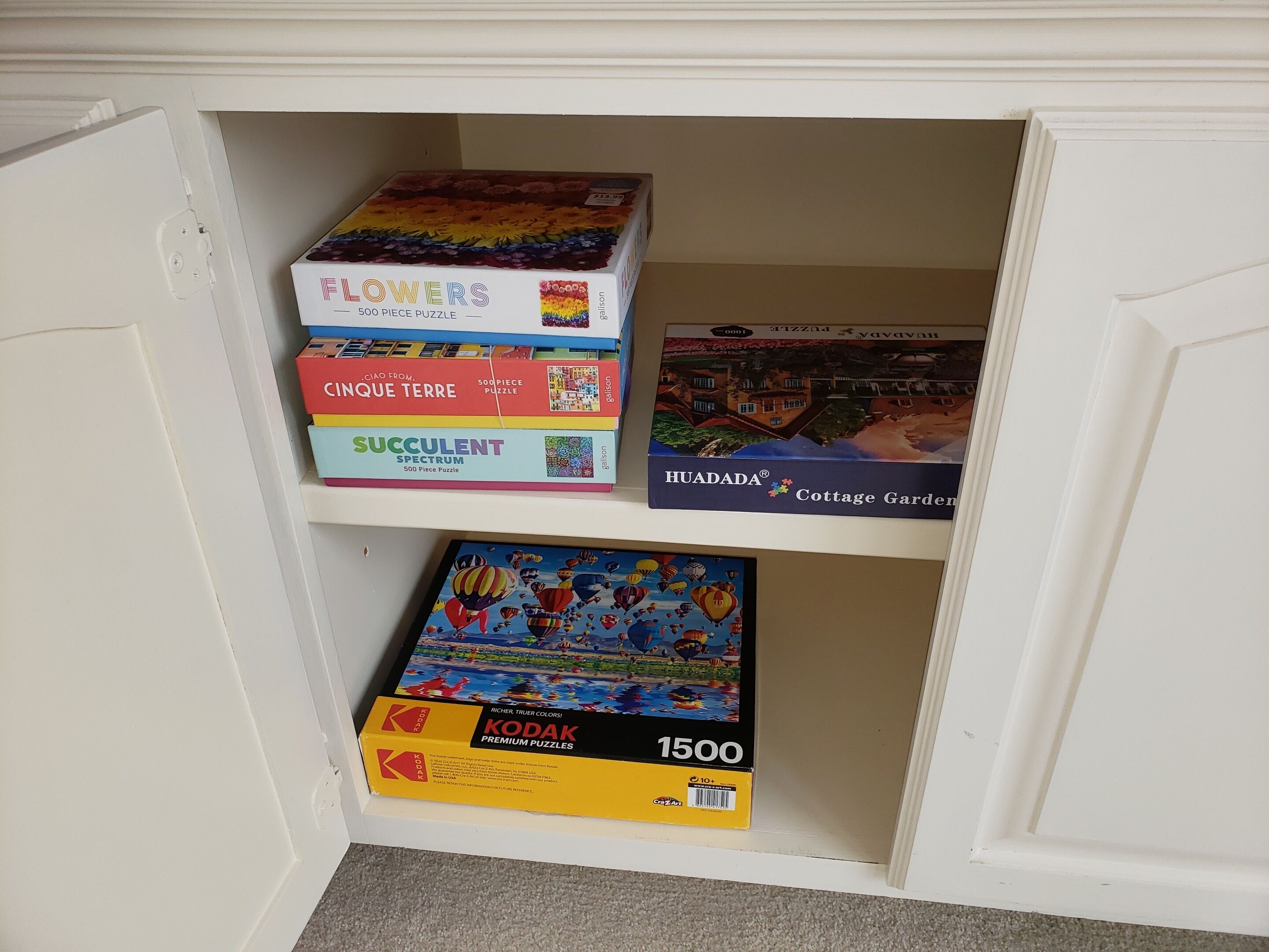 A shelf with four puzzle boxes.