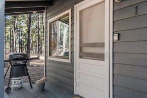 A covered porch with a grill, a bucket, and a door. - Aspen Ridge Retreat (Greer)