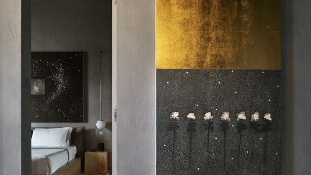 A modern bedroom with a minimalist design, featuring a bed with a wooden frame and a large abstract painting on the wall. - Fornace Suite (Florence)