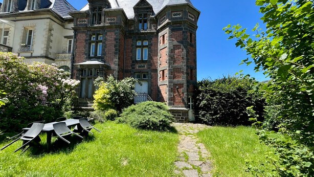 Un grand bâtiment historique doté d’une tour imposante et de nombreuses fenêtres.