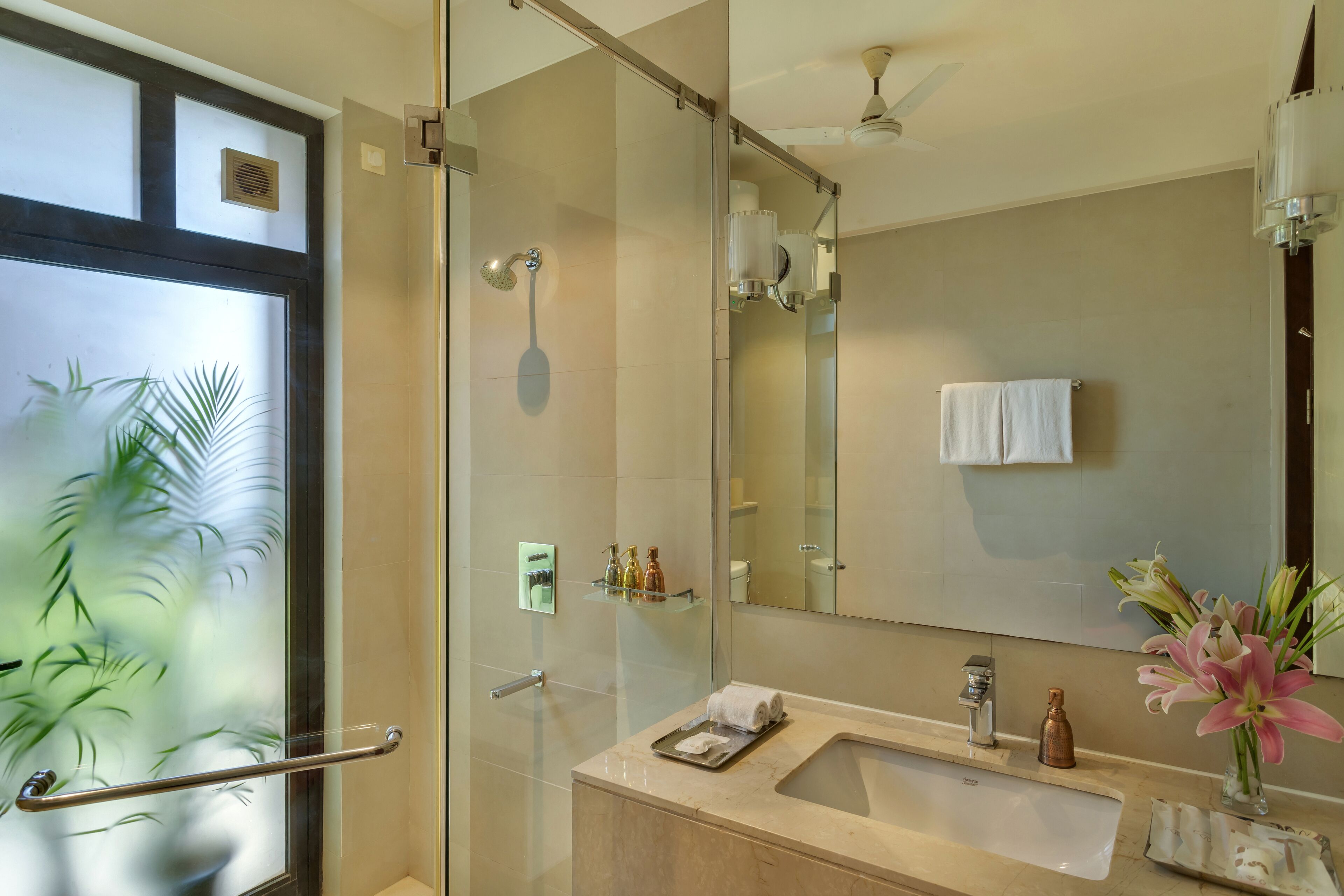Un bagno moderno con box doccia in vetro, un mobile lavabo e uno specchio grande.