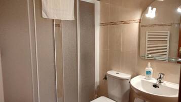 Un baño con ducha, inodoro y lavamanos.