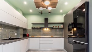 A modern kitchen with a herringbone floor pattern, a built-in oven, and a stainless steel refrigerator. - Amazonia Apt by halu! (Thessaloniki)
