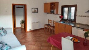 A compact living space with a kitchenette, a dining area, and a seating area.