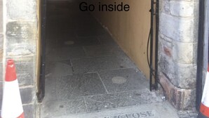 A narrow corridor with a sign reading "322 Go inside" and a plaque on the wall. - 2-bed Historic Apartment in old Town Edinburgh (Edinburgh)