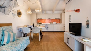 A compact living space with a kitchenette, a dining area, and a seating area with a sofa.