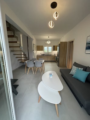 Um interior moderno com escada, área de refeições, cozinha e sala de estar.