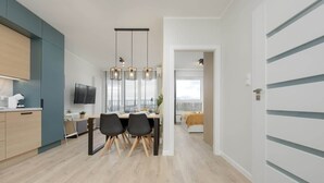 Una cocina moderna con comedor, televisor y un amplio ventanal.