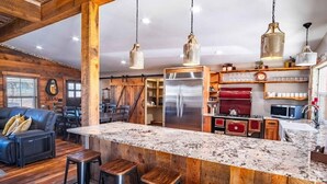 Una cocina moderna con una isla grande, detalles de madera y un estilo rústico.