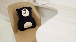A beige chair with a black and white bear-shaped pillow. - Bears Den Pattaya (Pattaya)