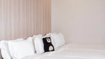 A neatly made bed with white bedding and a black and white pillow.
