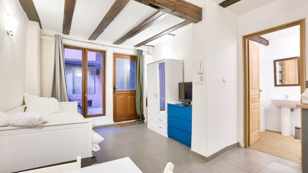 A modern apartment with a living room, a dining area, and a kitchen.